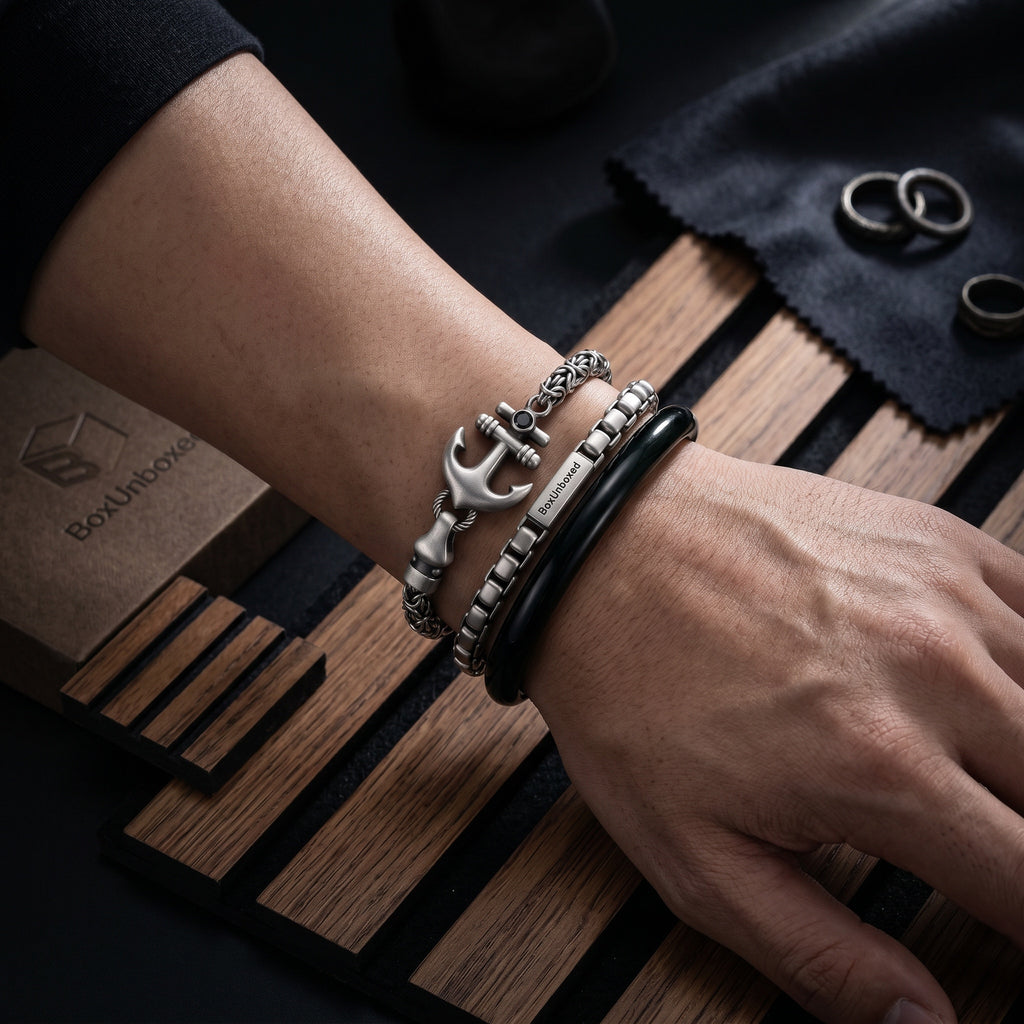 Close-up of a wrist wearing multiple bracelets on a wooden surface with a box in the background.