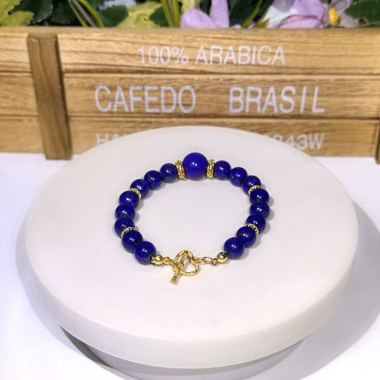 Hand-assembled natural Afghan Lapis Lazuli focal bracelet featuring a prominent 12mm centerpiece gemstone bead on a 10mm bead strand with gold accent spacers and an artisan gold heart toggle clasp.