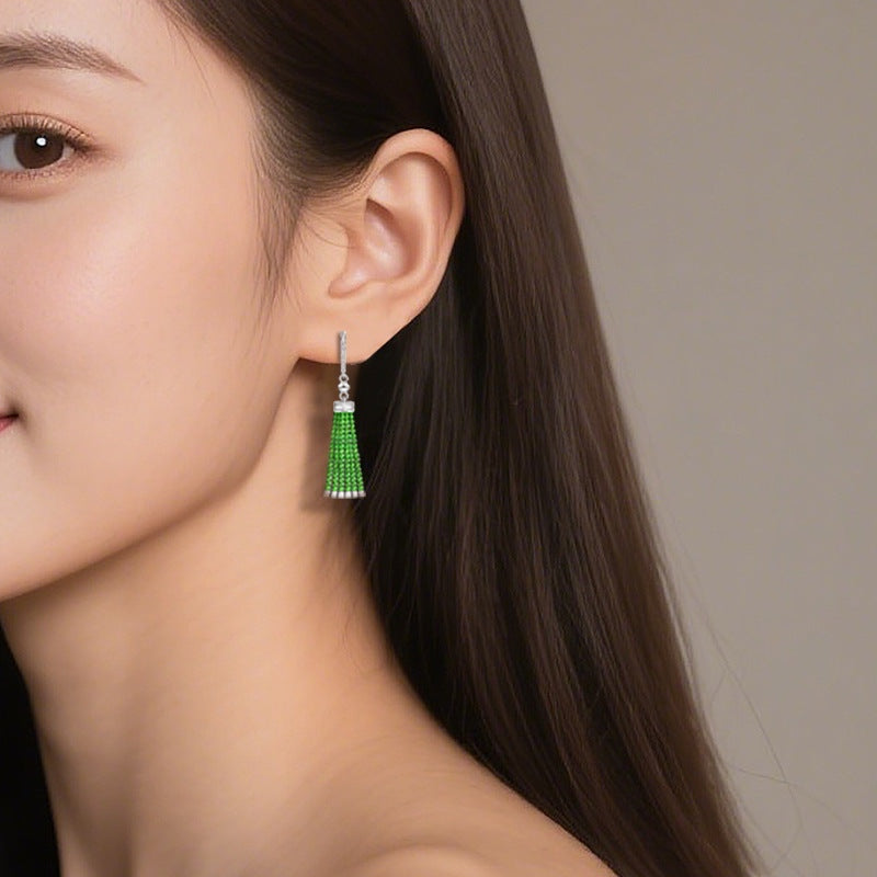 BoxUnboxed green jadeite beaded tassel drop earrings with pavé-set sterling silver huggie hoops worn by a model.