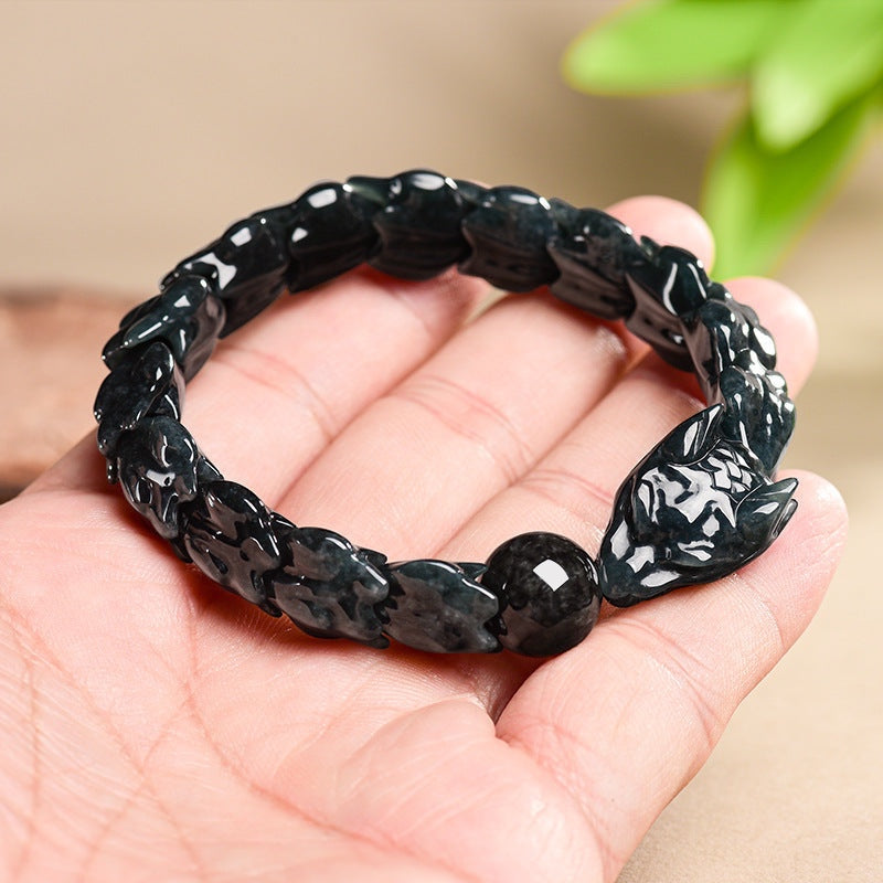 BoxUnboxed hand-carved jadeite dragon bones bracelet in dark teal and charcoal hues, featuring scale links and a dragon head clasp.