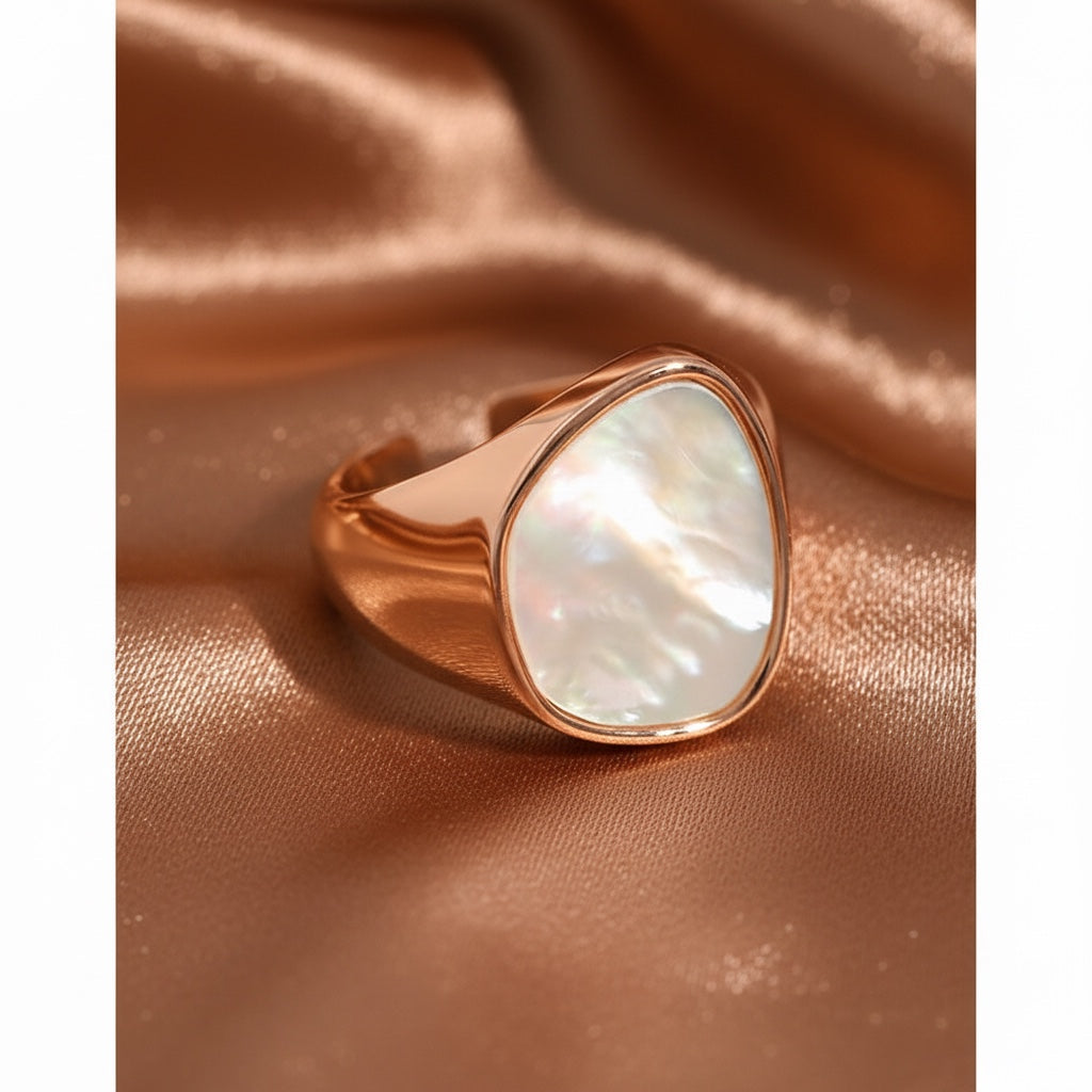 BoxUnboxed rose gold statement ring with a large, iridescent pearlescent inlay and a thick geometric band.